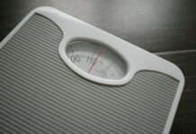 다이어트와 운동: 몸과 마음을 위한 긍정적인 변화 a bathroom scale sitting on top of a wooden table