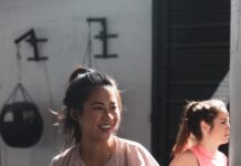 운동과 영양이 현대인의 삶에 미치는 긍정적 영향 woman in pink long sleeve shirt and black pants holding black kettle bell