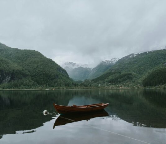 명상의 힘을 경험하라 – 현대인을 위한 마음 관리 방법 brown boat on body of water near green mountains under white sky at daytime