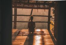 “마음 챙김, 일상에서 실천하기 쉬운 스트레스 해소법으로 주목” woman meditating on floor with overlooking view of trees