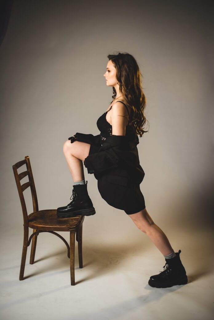 woman in black dress sitting on brown wooden chair