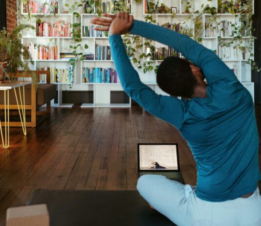 집콕 시간 늘어나는 요즘, ‘홈트’로 건강 챙기는 똑똑한 방법 a man doing yoga in a living room